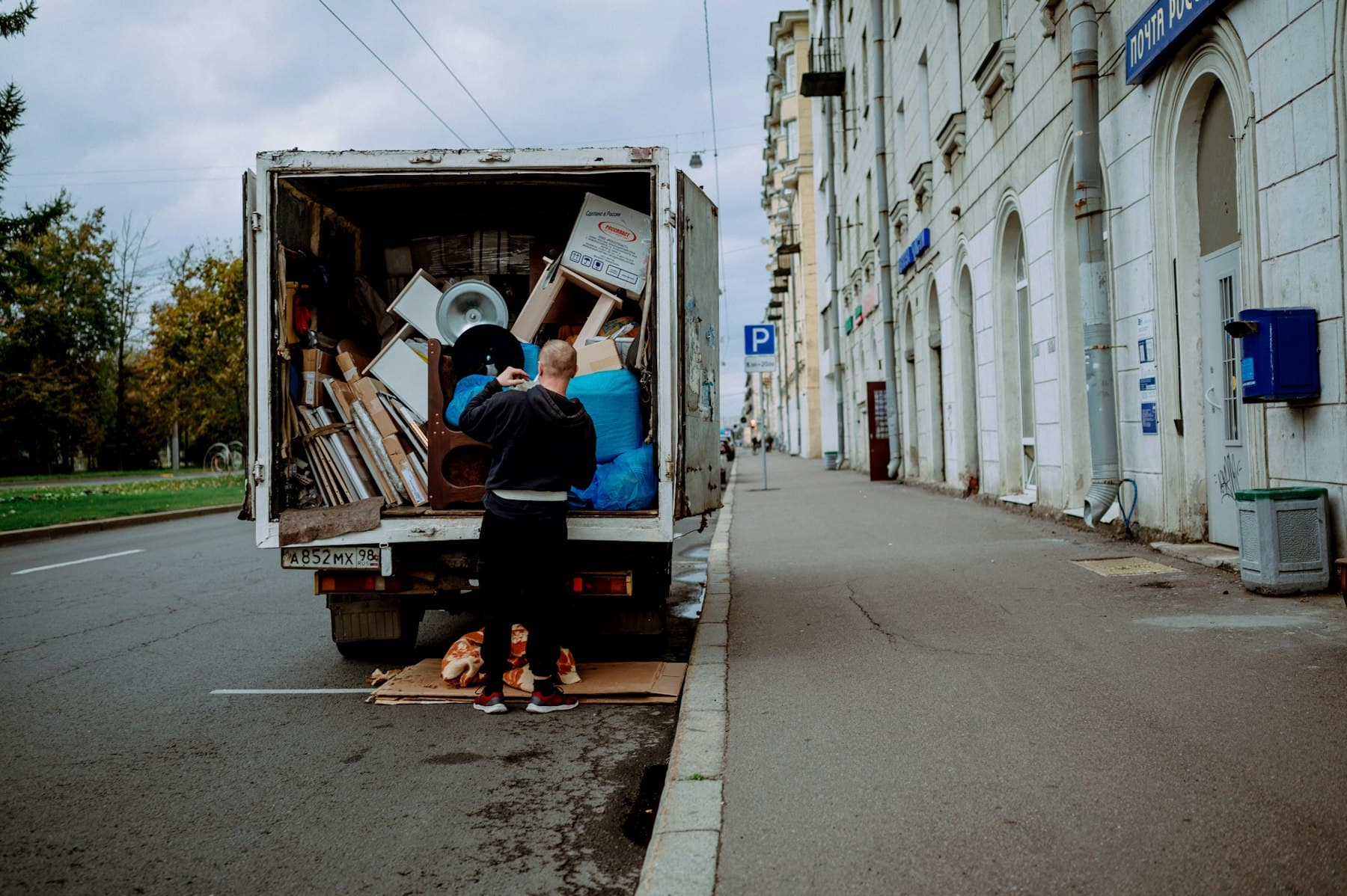 Worker loading mixed furniture into a box truck