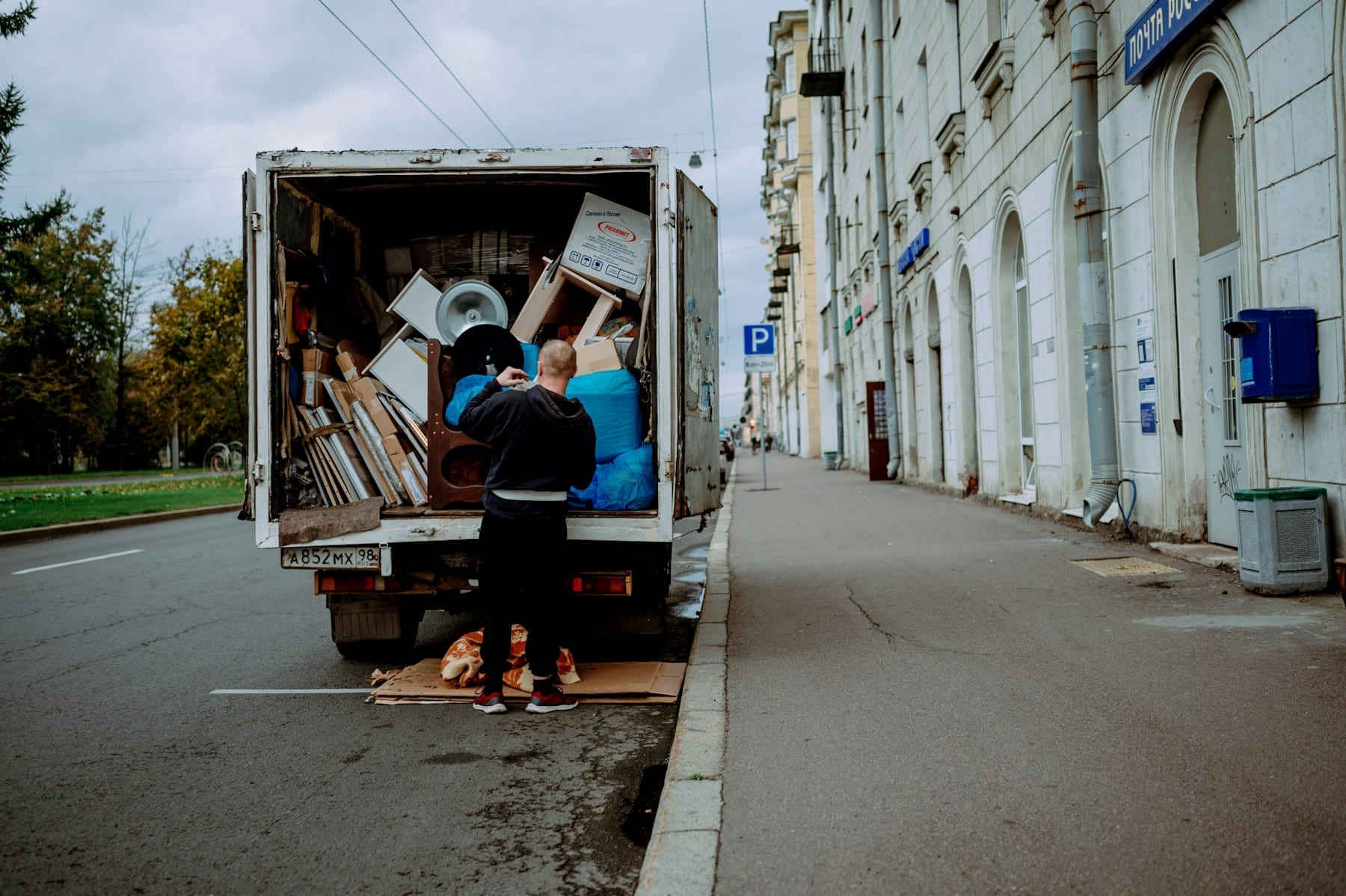 Worker loading mixed furniture into a box truck